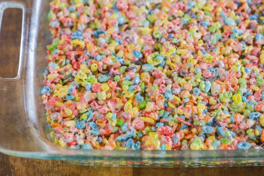 Fruity pebble rice crispy treats pressed in a glass pan.