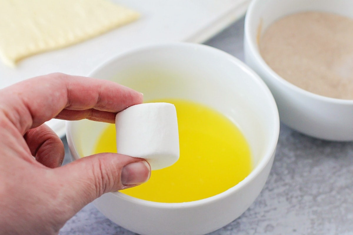 Dipping a jumbo marshmallow in melted butter.