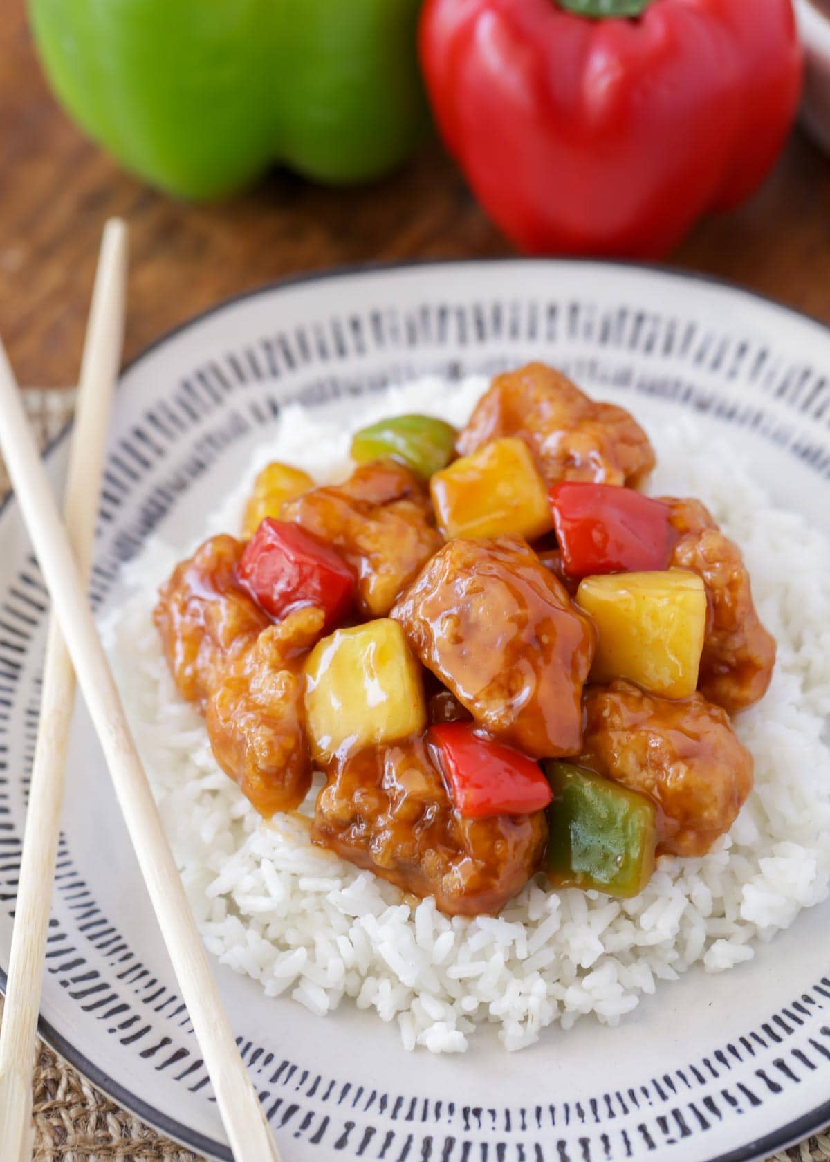 Sweet and sour chicken recipe with white rice on a white and grey plate.