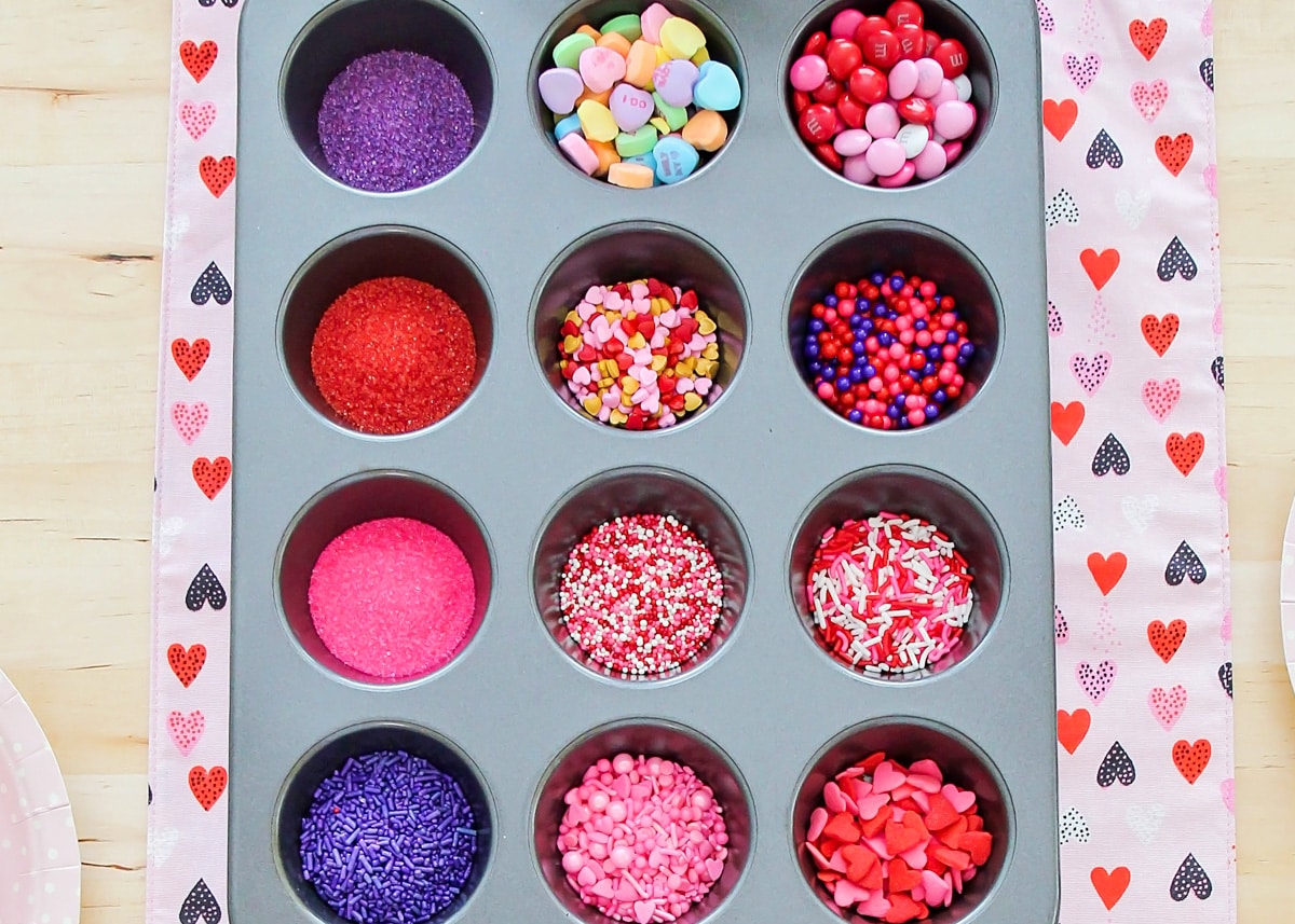 Valentine sprinkles in muffin tin.