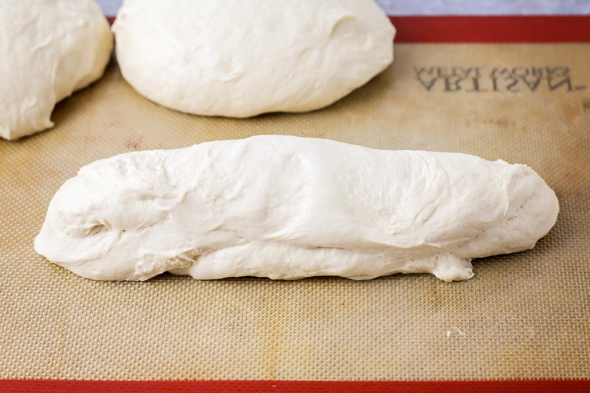 Shaping bread dough into a baguette.