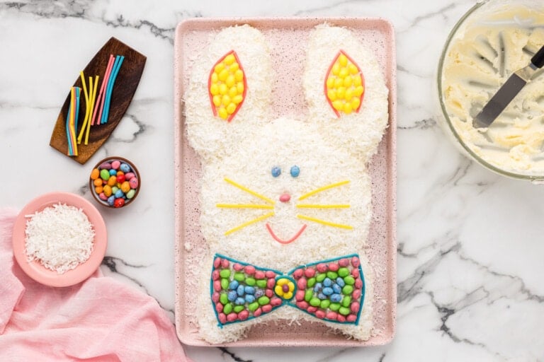 Easter Bunny Cake with all the fixings around it on the counter.