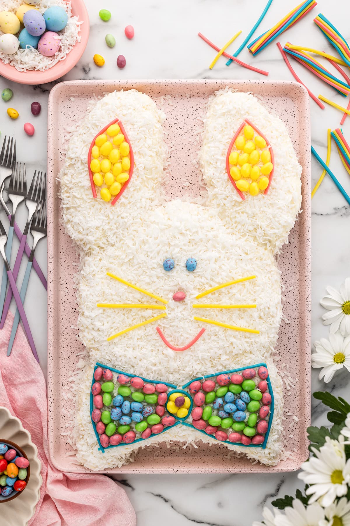 Top view of an easter bunny cake decorated with coconut and candy.