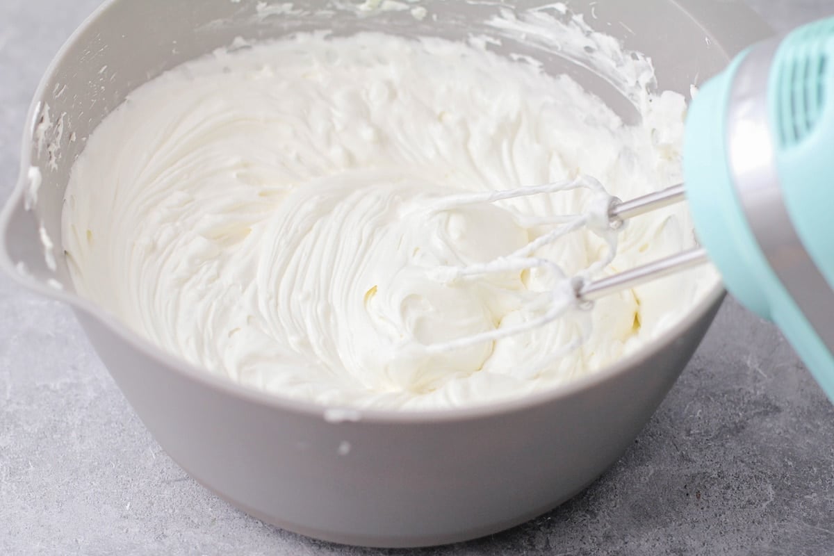 A white bowl filled with a whipped cream cheese mixture.
