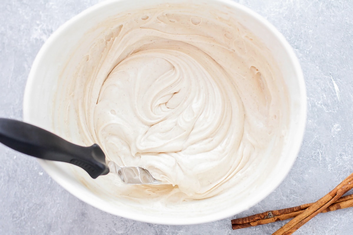 Mixing cream cheesing frosting with cinnamon.