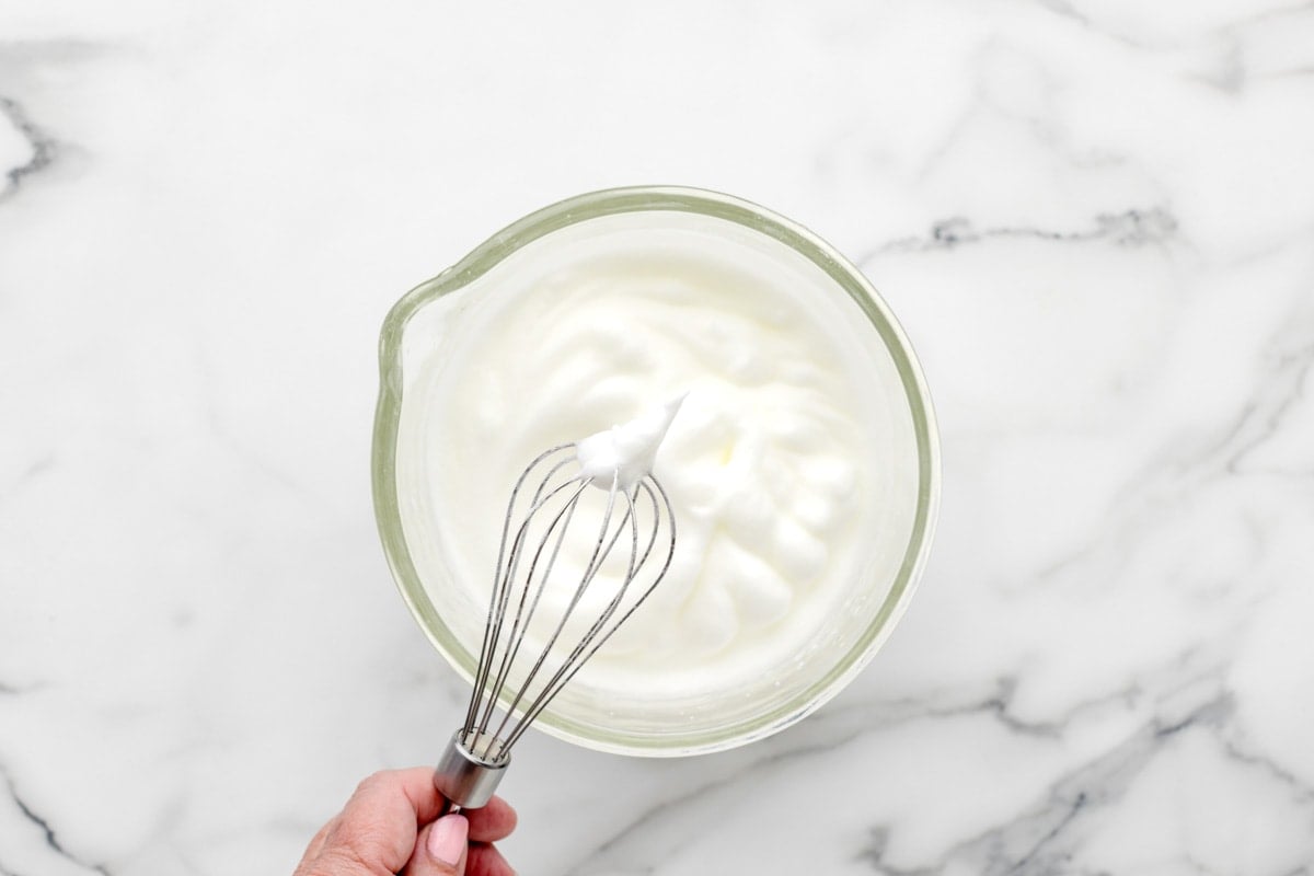 Whipping egg whites in a glass bowl.