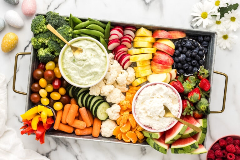 Easter charcuterie board filled with snacks, dips, veggies and fruits.