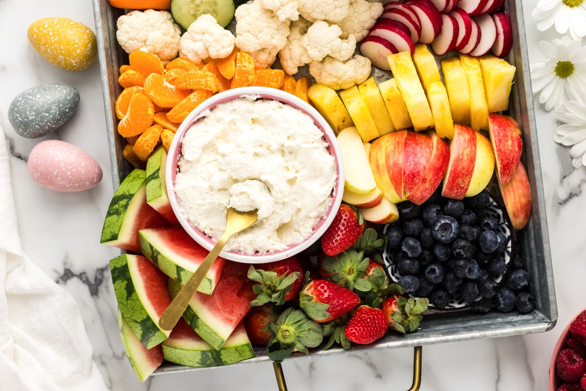 Close up of fruit dip and fruit on a charcuterie board.