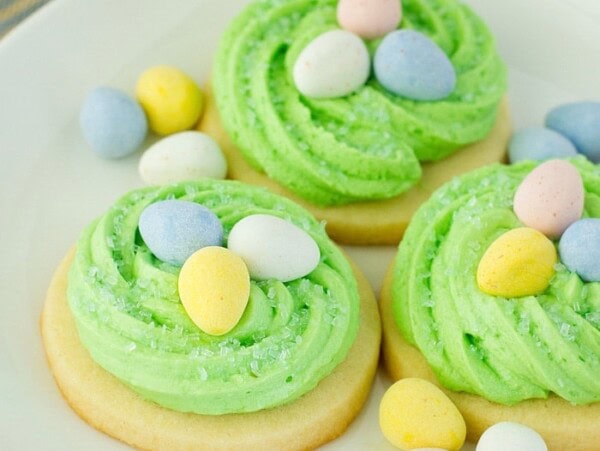 Adorable Easter sugar cookies topped with green frosting and cadbury eggs.