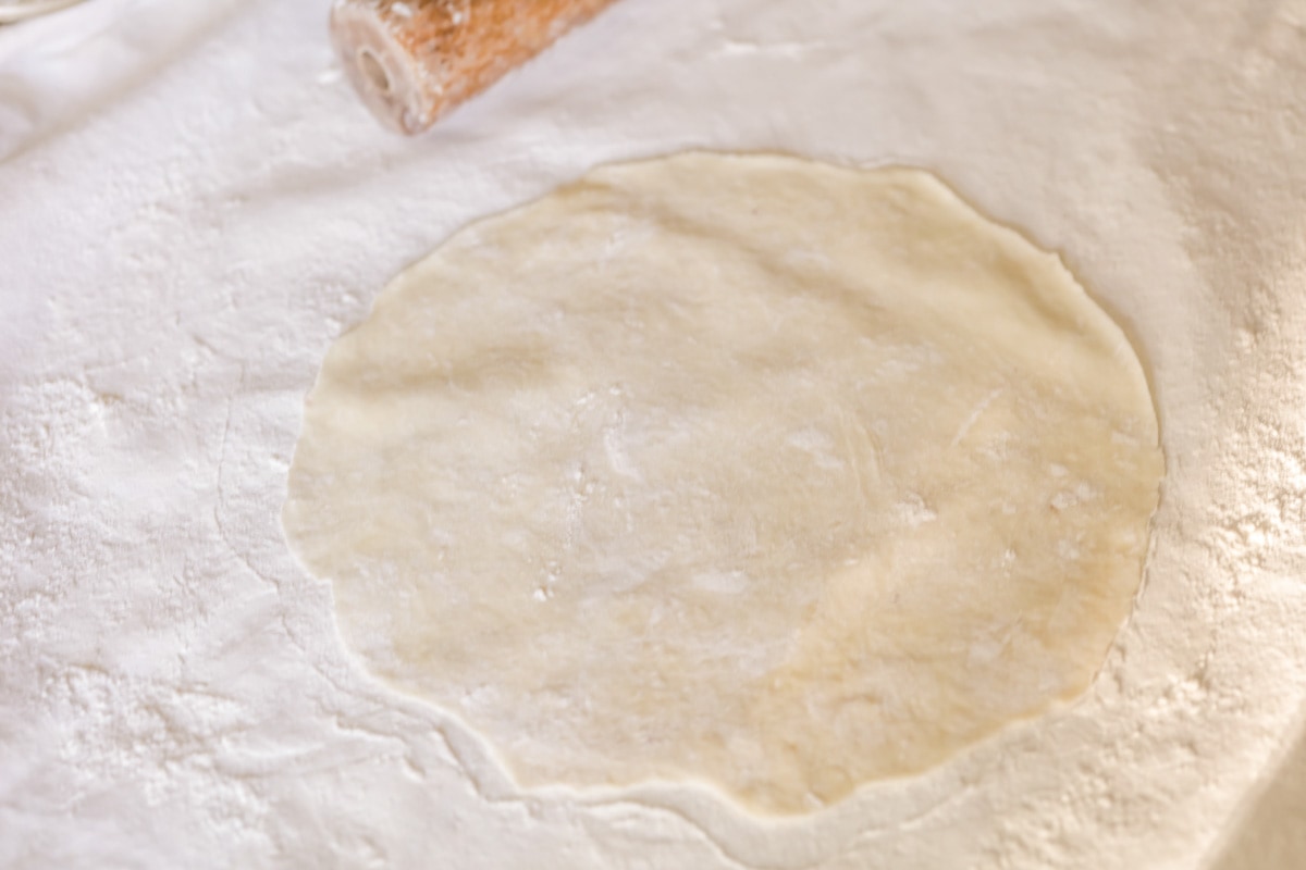Empanada dough rolled out on floured surface.