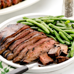 Flat iron steak recipe sliced and served with green beans.