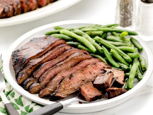 Flat iron steak recipe sliced and served with green beans.