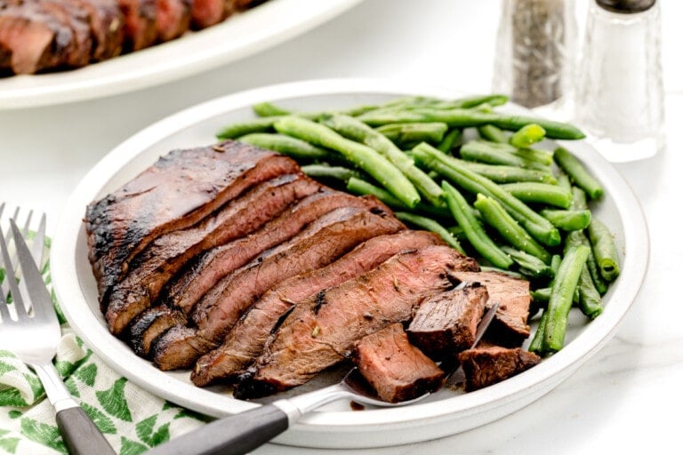 Flat iron steak recipe sliced and served with green beans.