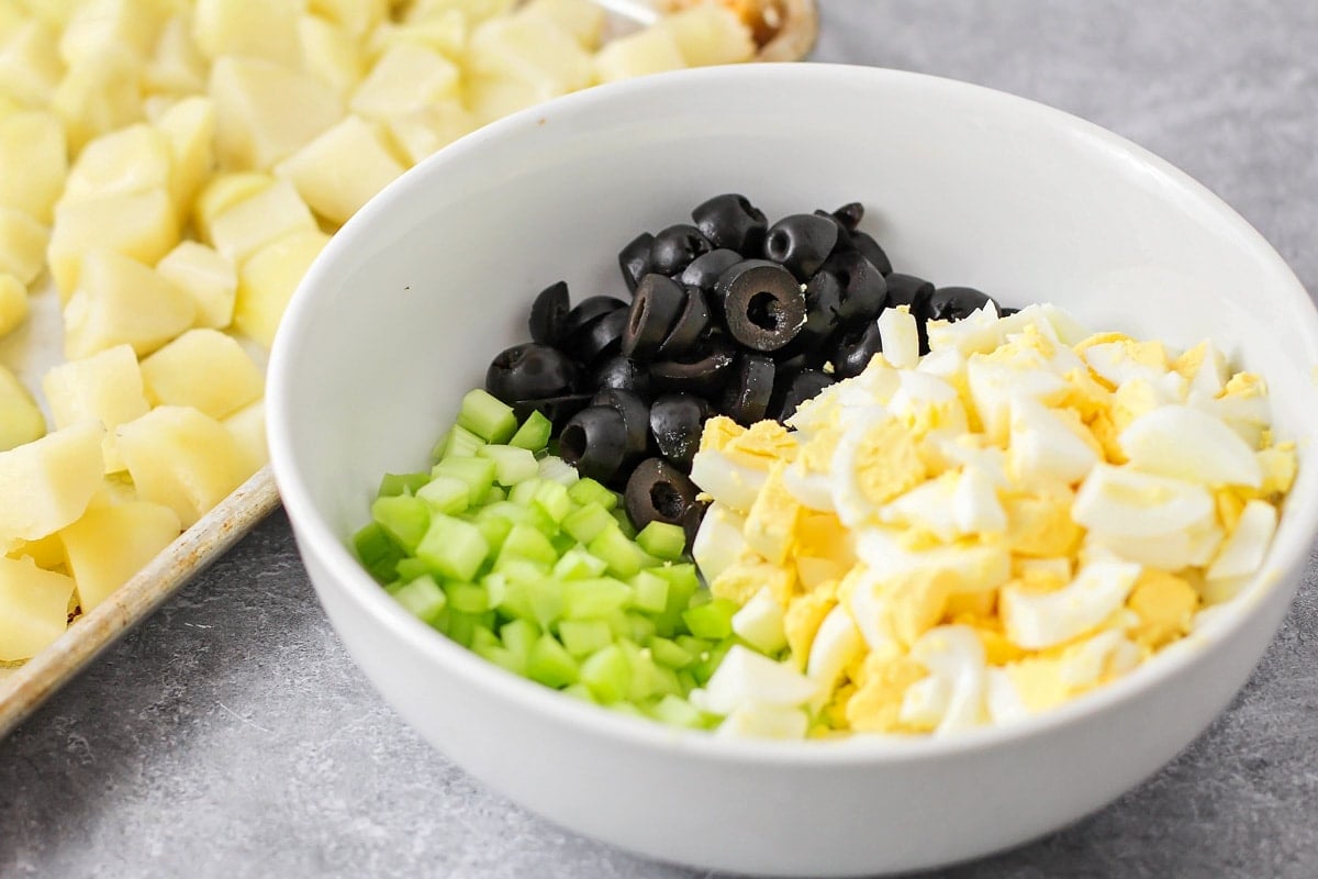 A bowl of chopped black olives, celery, and hard boiled eggs.