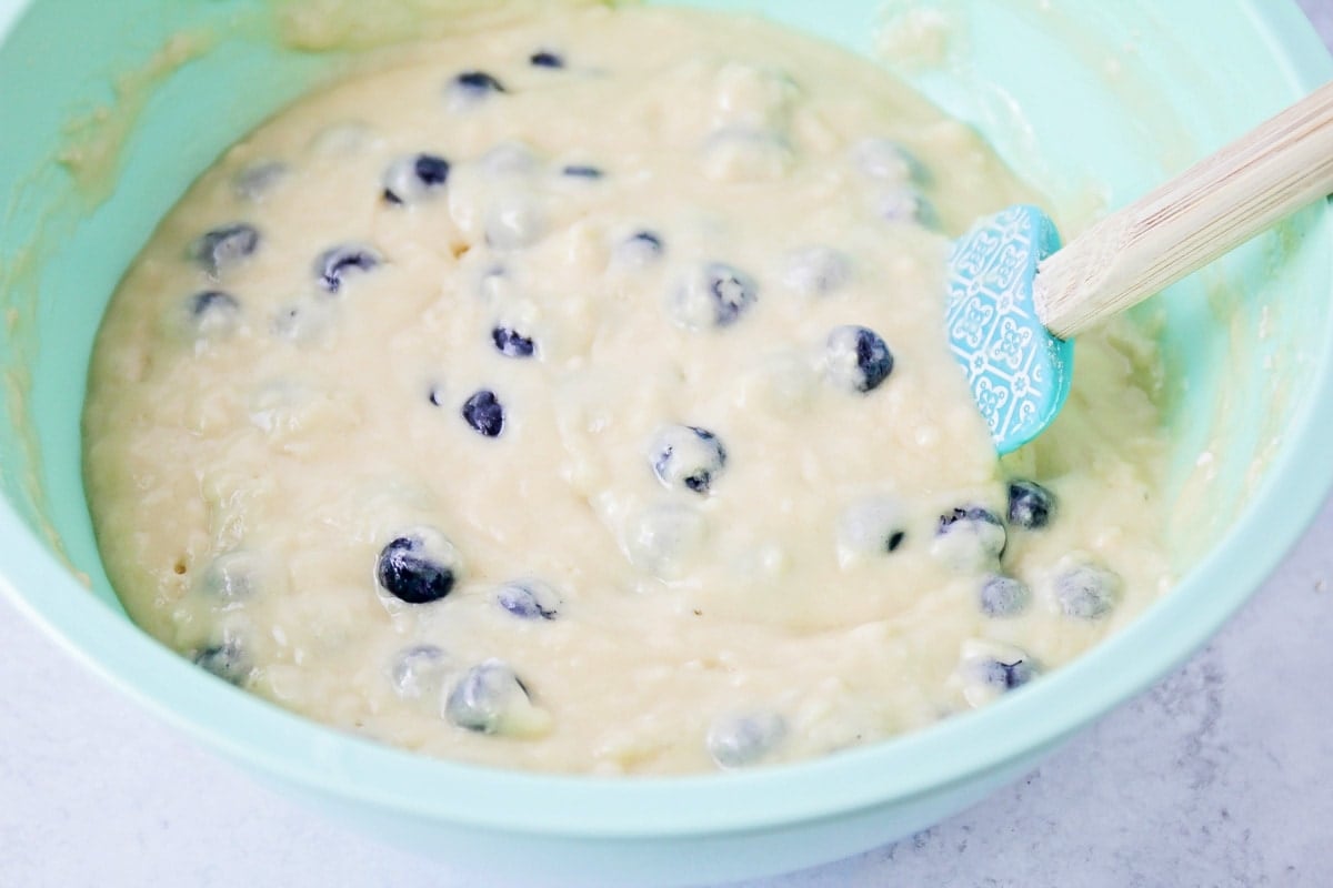 Blueberries mixed into a muffin batter.