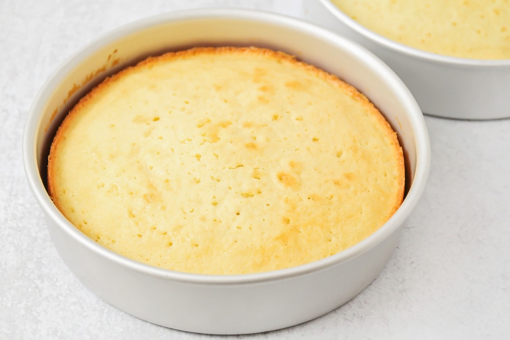 A cooked lemon cake in a round pan.