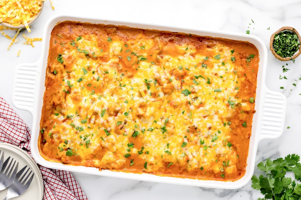 Top view of a cheesy Mexican casserole in a white dish.