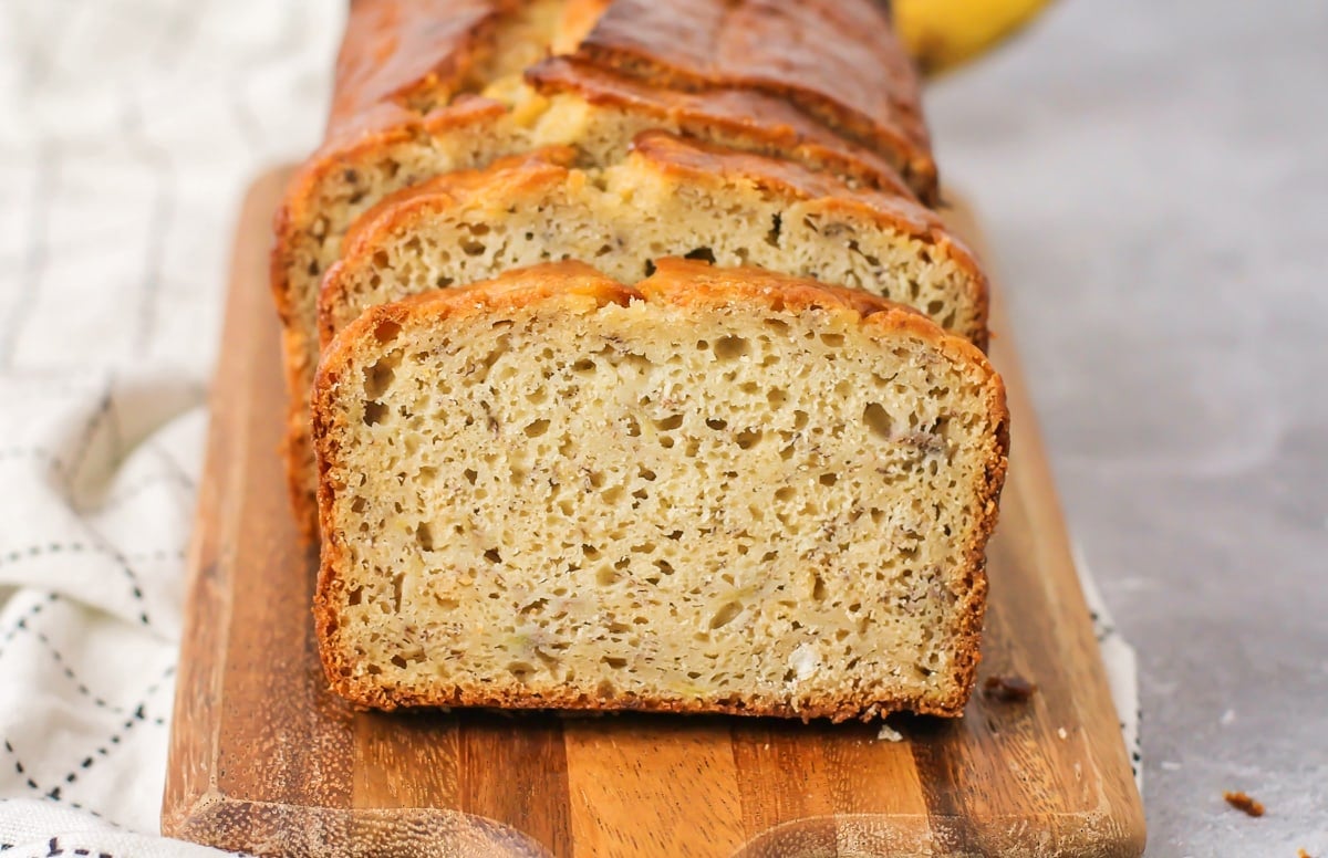 Close up view of a loaf of sliced moist banana bread.