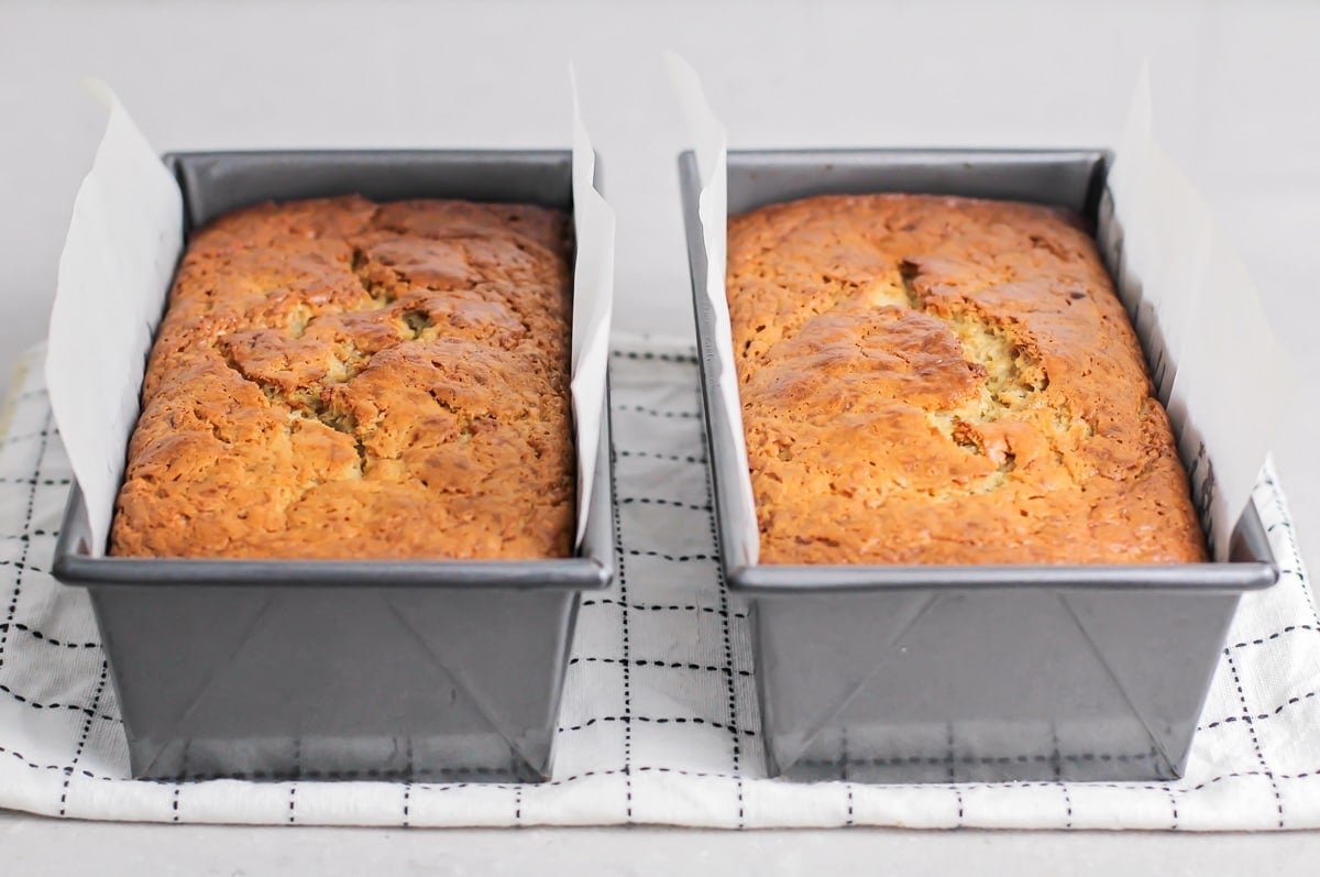 Two lined loaf pans of baked banana bread.