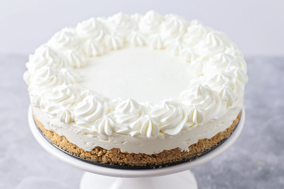 A cheesecake topped with whipped cream.