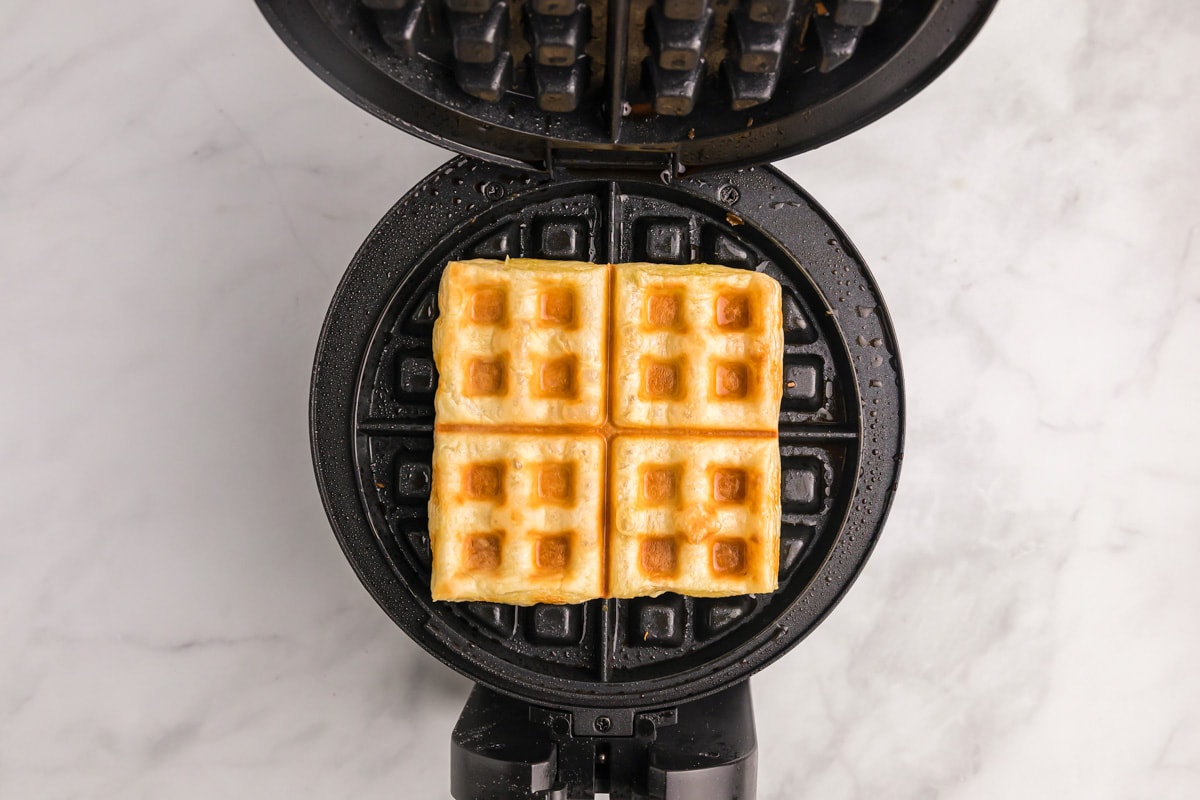 Cooked puff pastry on a waffle iron.