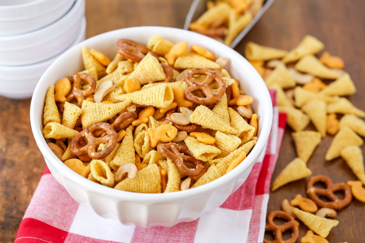 A white bowl filled wtih snack mix.