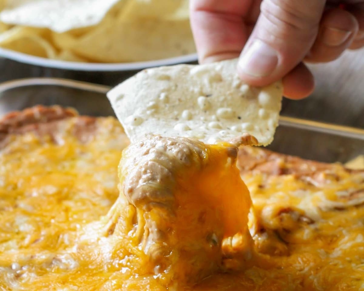 Chip being dipped into the best bean dip recipe.