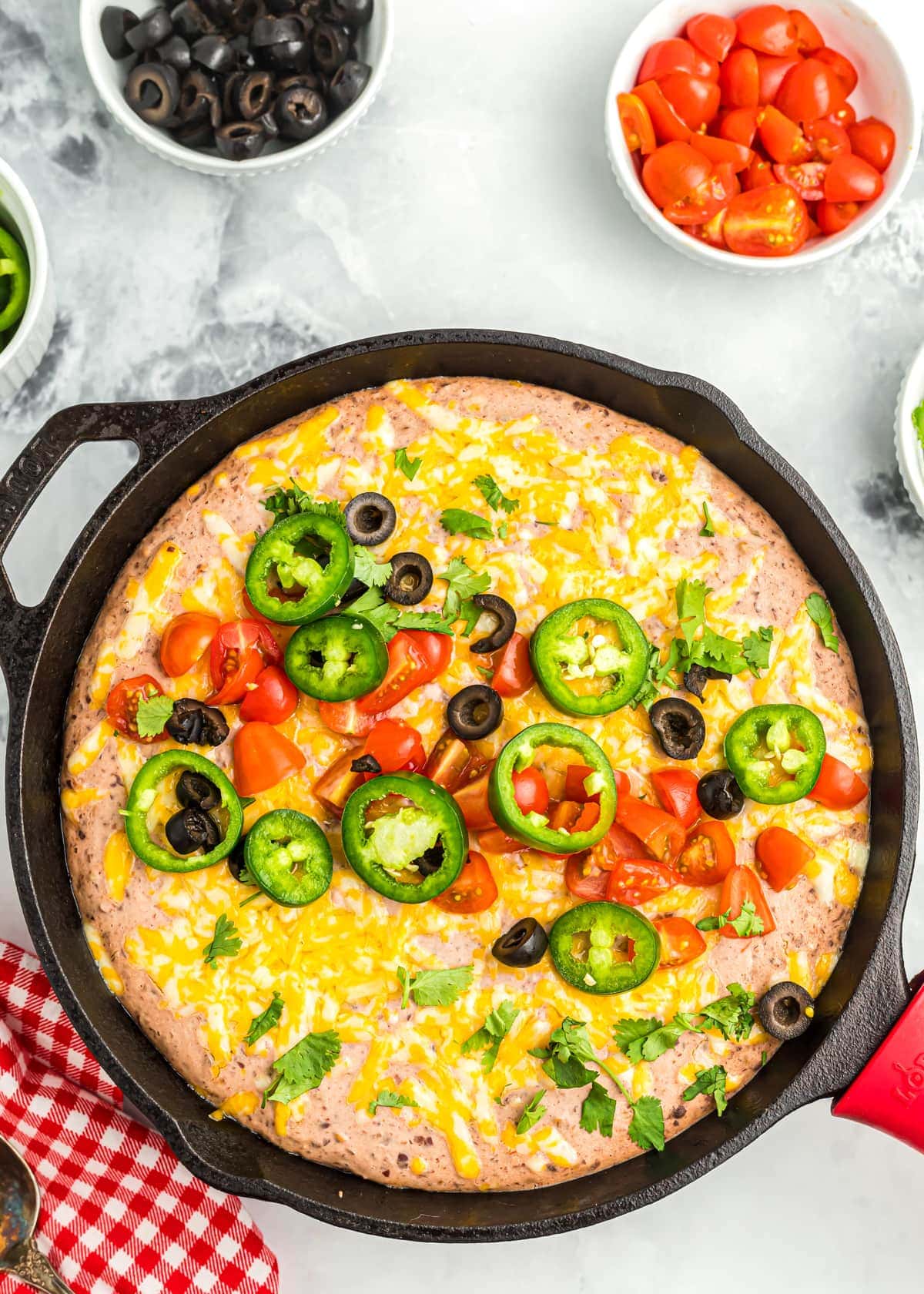 Black bean dip topped with jalapenos and diced tomatoes and black olives.