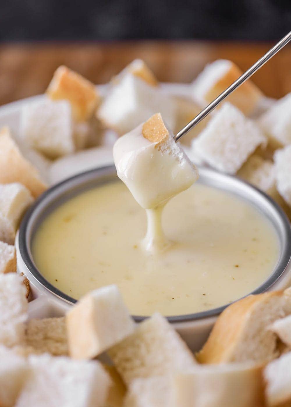 Dipping cubed bread into cheese fondue.
