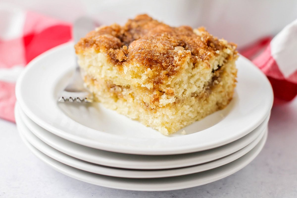 Slice of coffee cake on 4 white stacked plates.