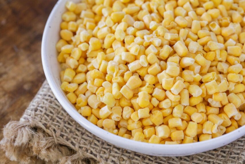 Frozen corn in white bowl.