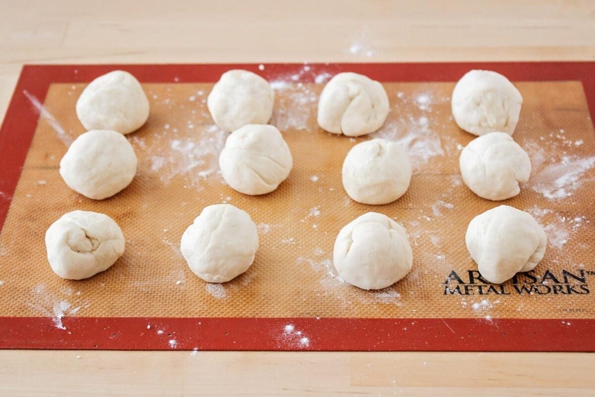 Flour dough balls rolled on a mat.