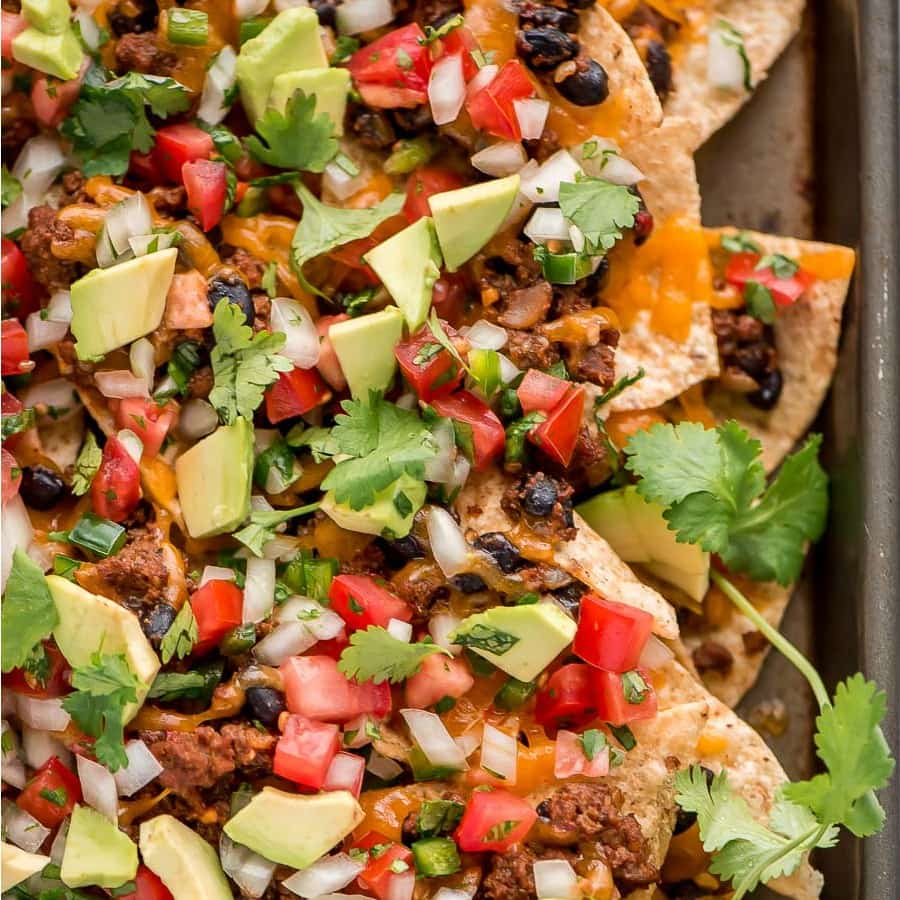 Loaded nachos piled high with taco ingredients.