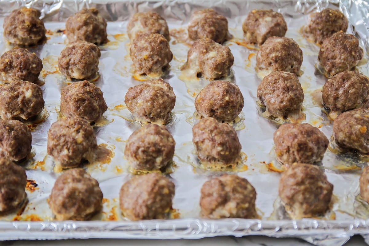 Cooked meatballs on baking sheet.
