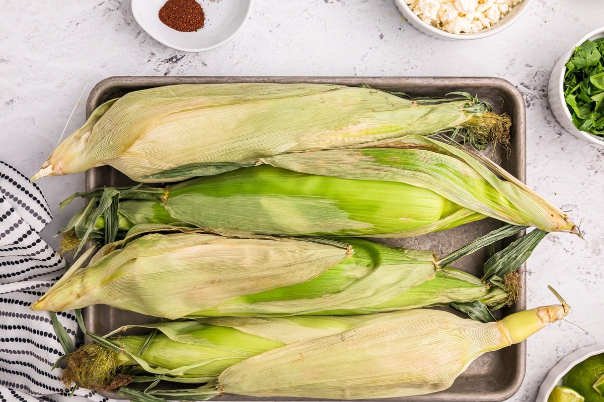 A sheet pan topped with corn on the cob.