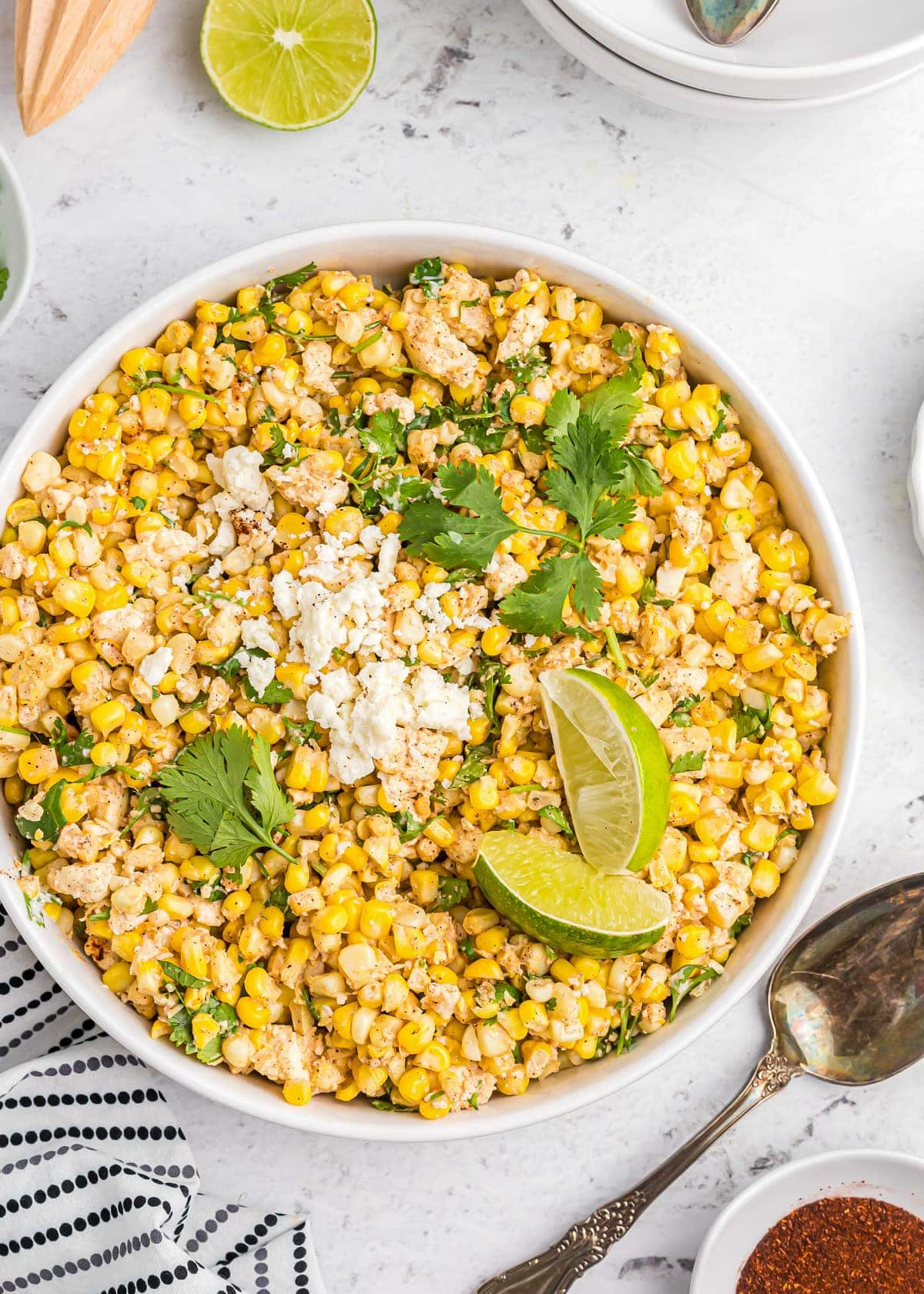Close up of a bowl filled with Mexican Corn Salad topped with cotija and cilantro.