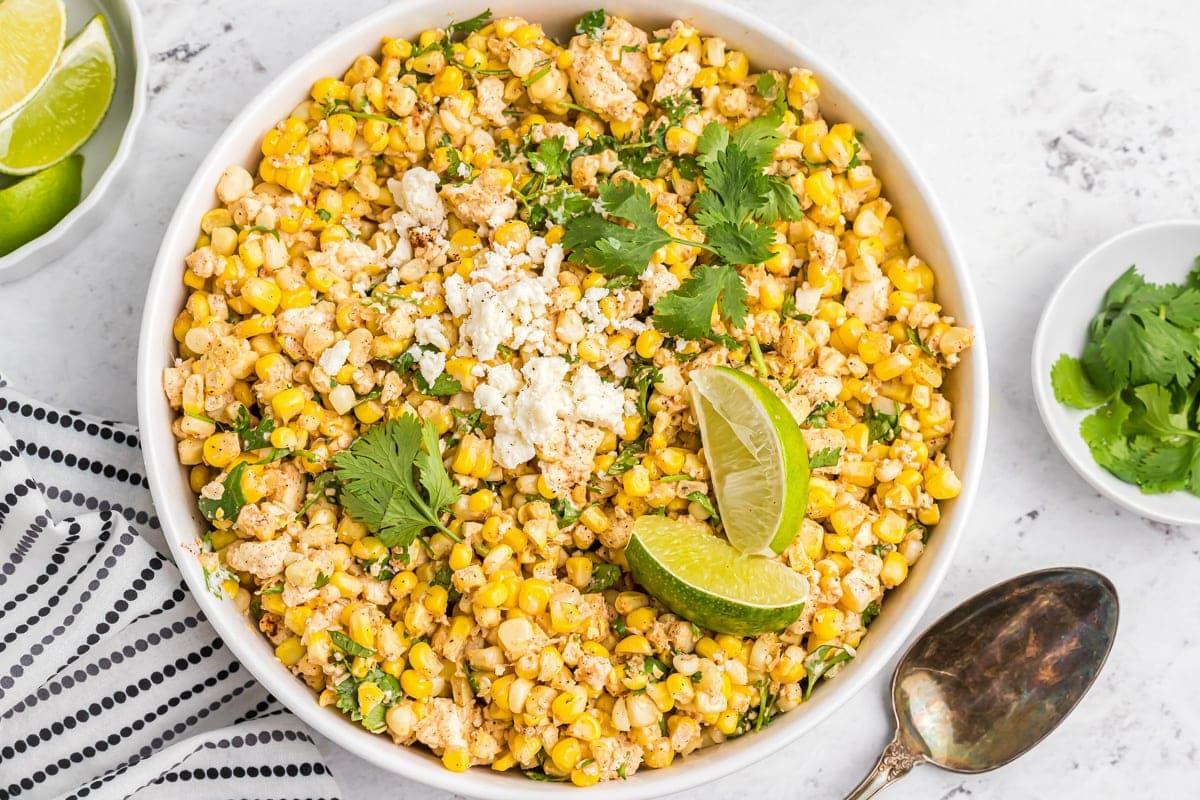A bowl filled with Mexican Corn Salad topped with cotija and cilantro.