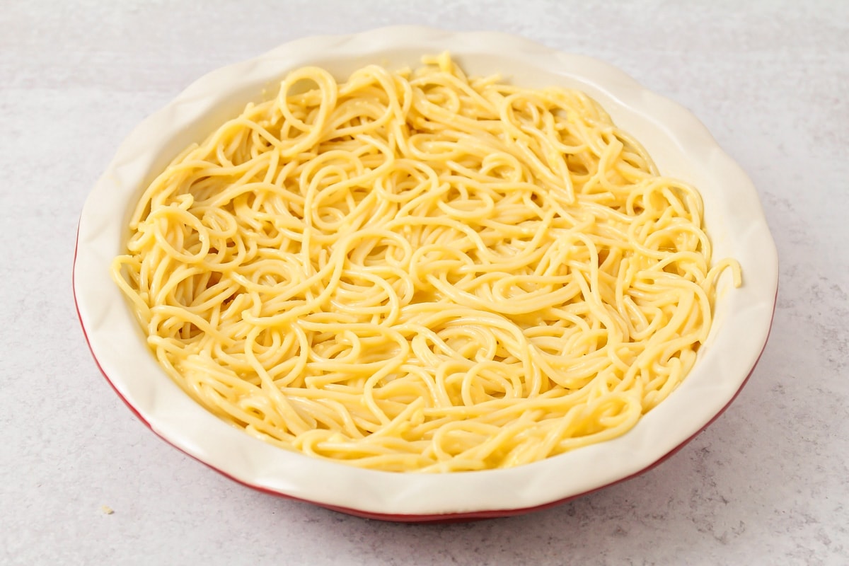 Noodles in pie dish for spaghetti pie.