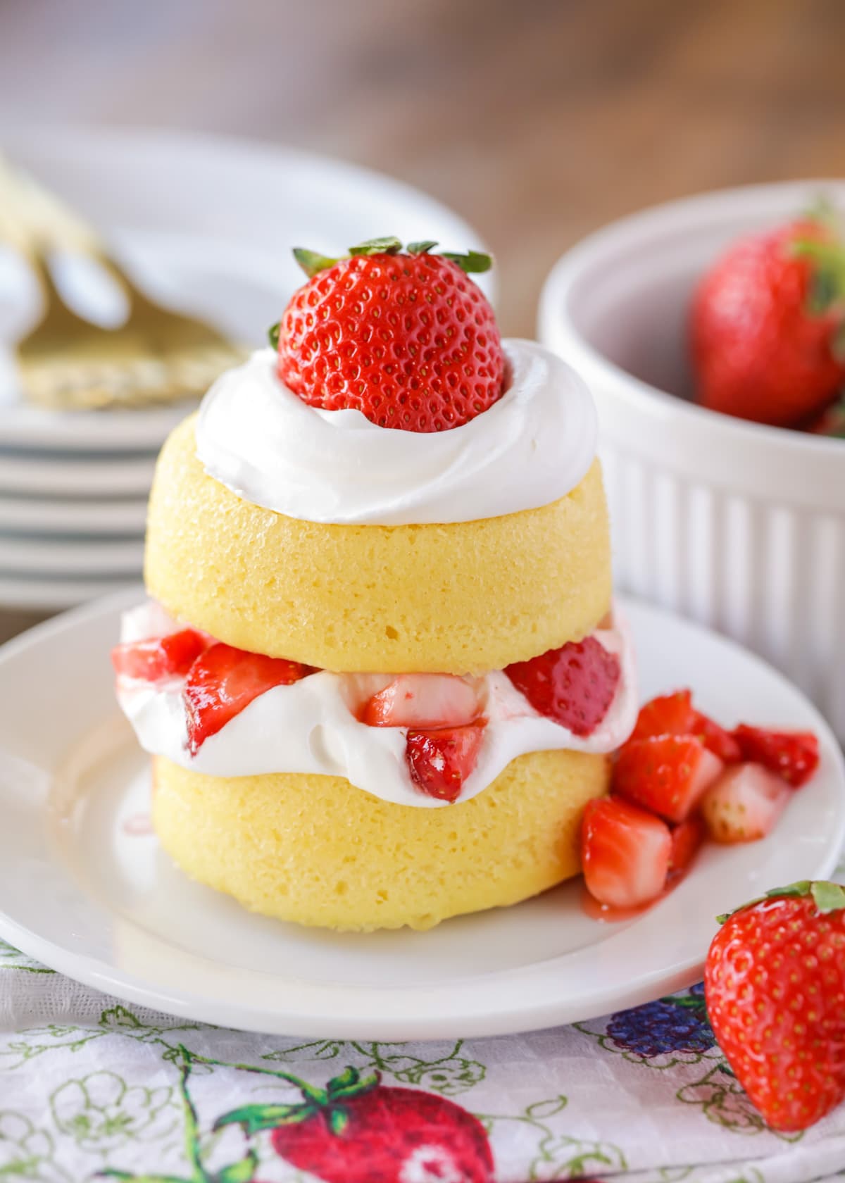 Easy strawberry shortcake topped with whipped cream and strawberries on a white plate.
