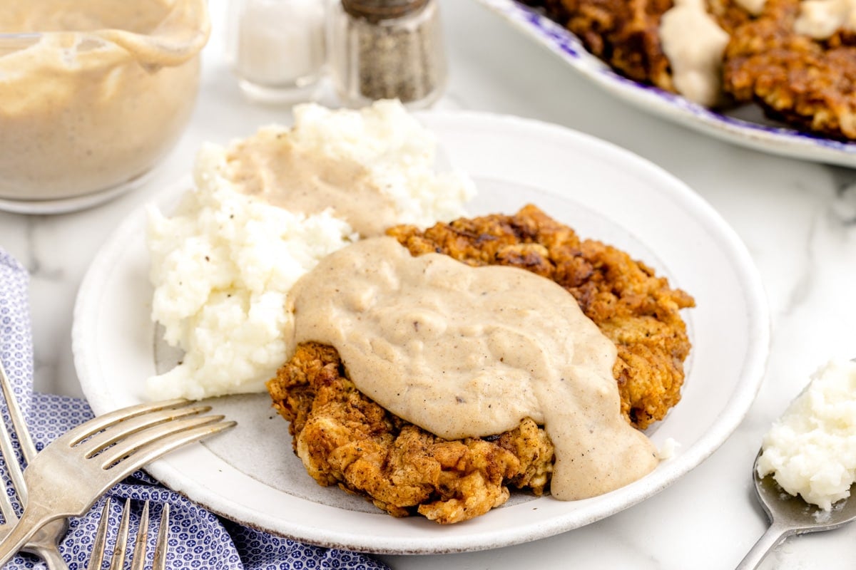 Country fried steak and mashed potatoes covered in homemade gravy.