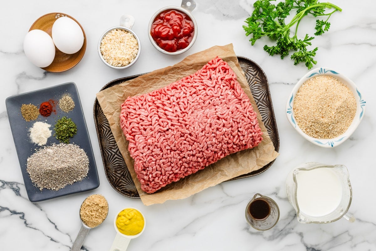 Ground beef and seasoning measured and set out on a kitchen  counter.