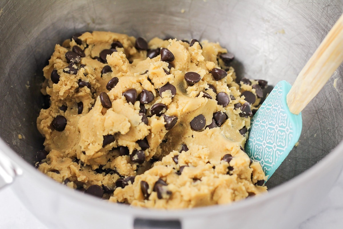 Mixing chocolate chips into cookie dough batter.