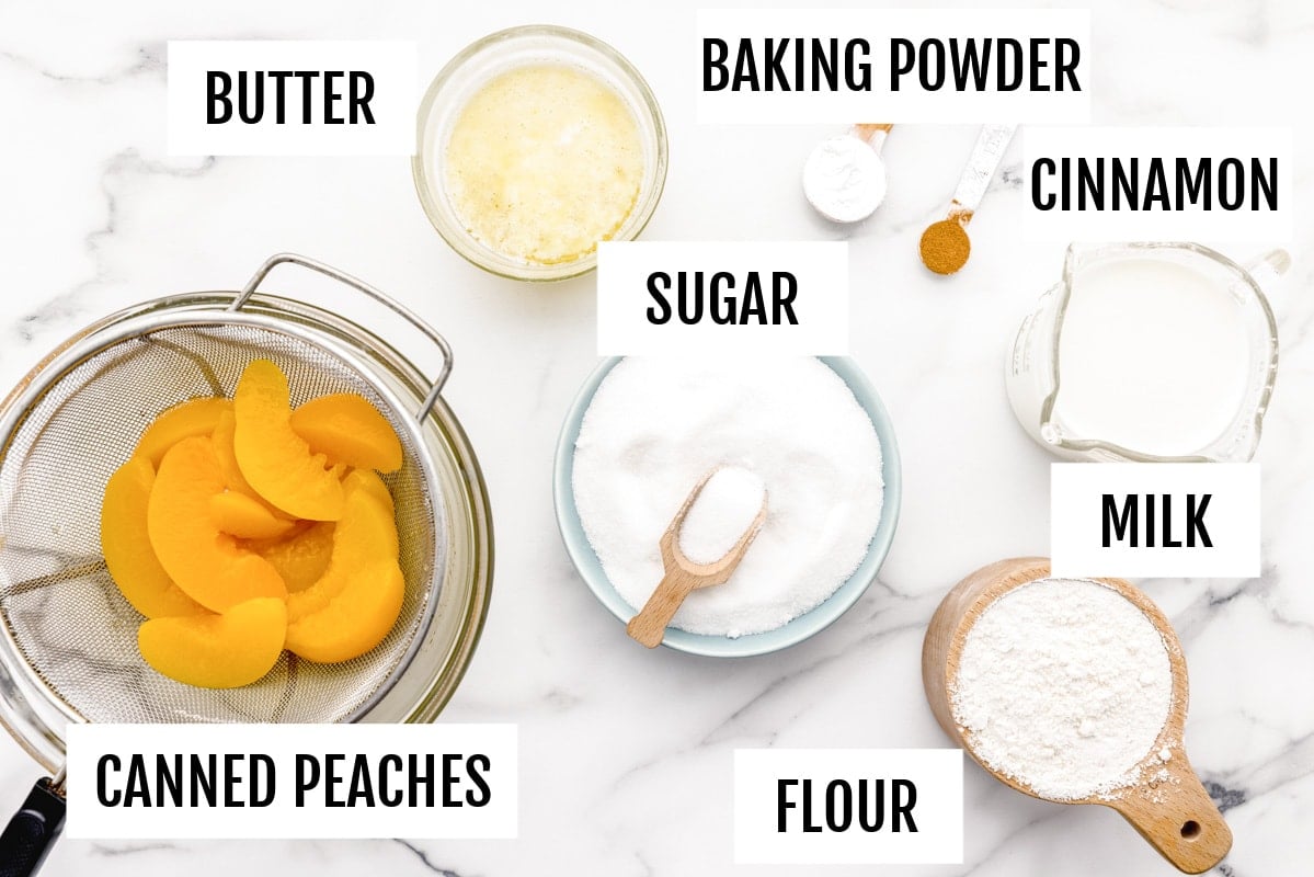 Peach cobbler ingredients on marble counter.