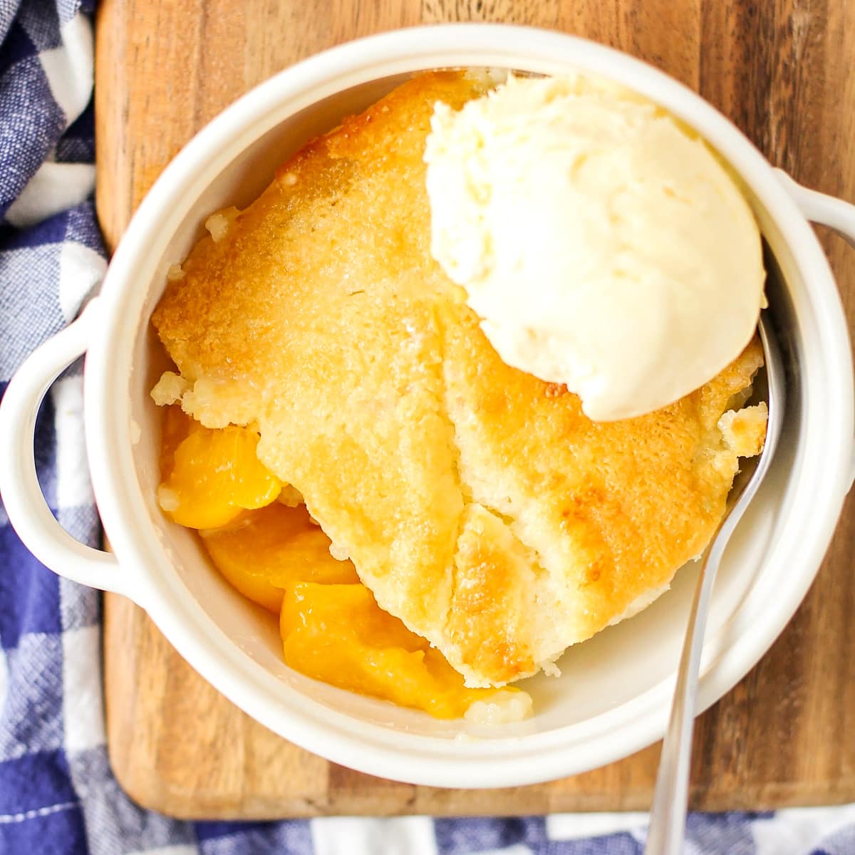Easy peach cobbler recipe close up image with ice cream on top.