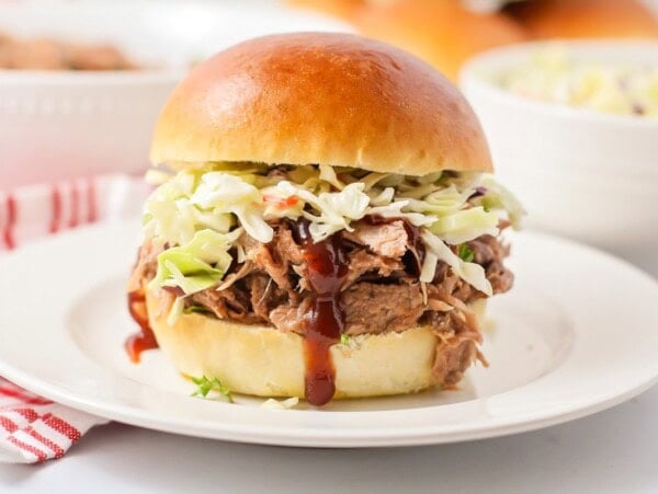 An easy pulled pork recipe shredded and served with coleslaw on a bun.