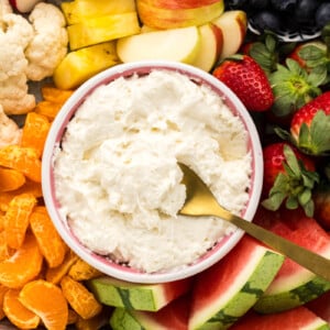 Yogurt fruit dip served in a bowl alongside fresh fruit.