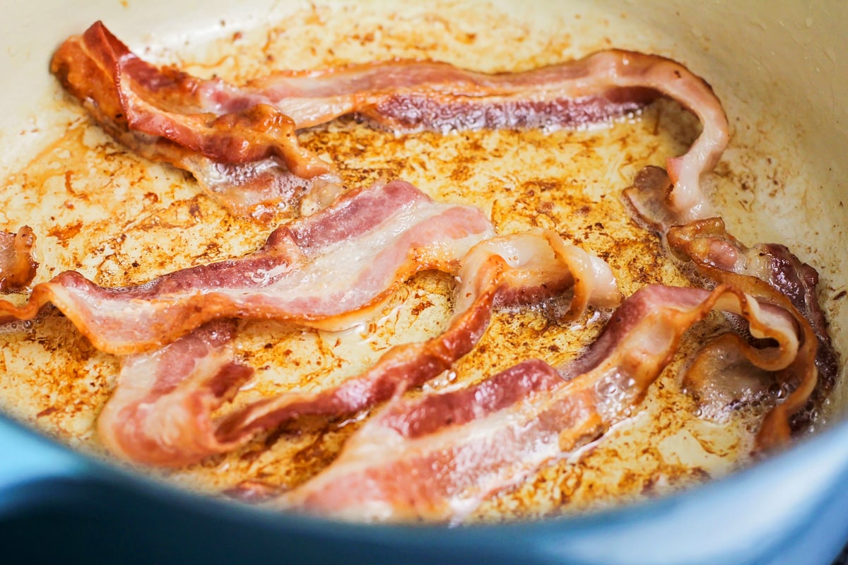 Bacon cooking in a dutch oven.