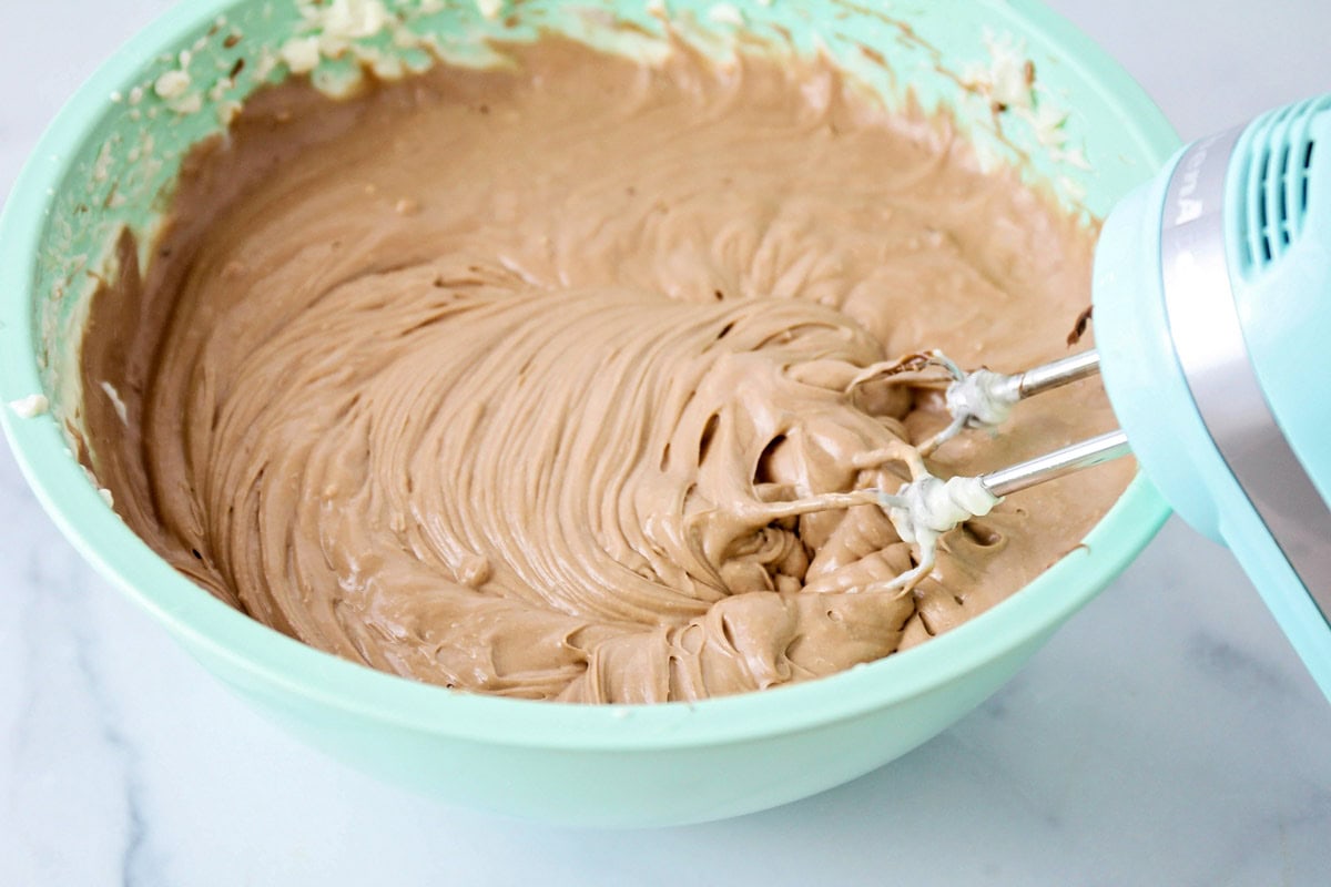 Combining melted chocolate with whipped cream mixture.
