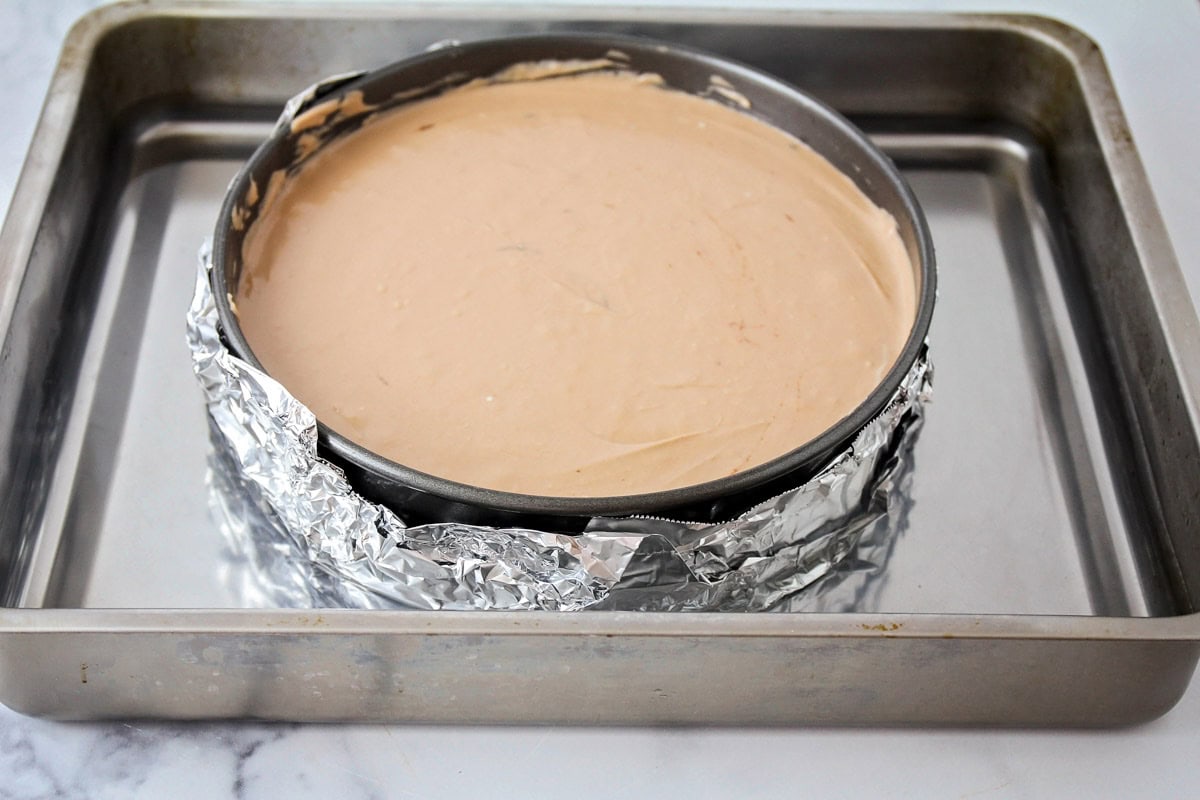 Chocolate cheesecake filling in a springform pan ready to bake in the oven.