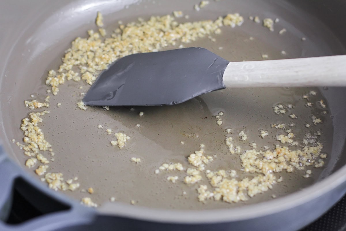 Cooking garlic in a skillet on the stove.